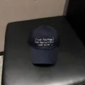 Detailansicht der gewaschenen Jeans-Baseballcap mit weißer bestickter Textgrafik vorne. - Verstellbar / Marineblau