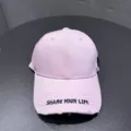 Close-up detail of the pink baseball cap featuring embroidered text on the curved brim. - Adjustable / Pink