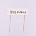 Detailaufnahme des goldenen Happy Birthday Torten-Toppers mit eleganter Schrift auf Flagge. - Gestreifter Stil / Gold
