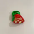 Gros plan détaillé de la bague fraise en résine avec de jolis strass et des détails. - Fraise