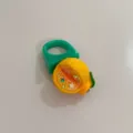 Gros plan de la bague chunky en résine verte Y2K avec un détail de pendentif d'agrumes. - Orange