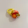 Bague statement Y2K en résine avec un anneau jaune large et un motif de fruit ludique. - Grenade avec Base Jaune