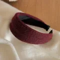 Detailaufnahme des dunkelroten gestrickten breiten Haarreifs, gemütliches Accessoire. - Rot