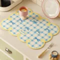 Detail view of American retro checkered leather kitchen draining mat with cute bow motifs. - Sweet Cheese