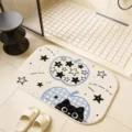 Detailed shot of cute cartoon black cat bath mat with blue apple pattern for bathroom floor. - Starlight Cat Fruit