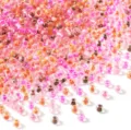 Close-up detail view of colorful glass seed beads in mixed pink and orange for DIY jewelry. - 4mm (Approx. 450g/Bag) / Dyed Core Pink