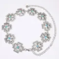 Detailopname van de zilveren metalen kruis tailleketting met prachtige turkoois stenen. - Zilver