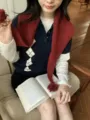 Dettaglio di sciarpa triangolare a maglia con tessuto rosso e ponpon per l'inverno. - Marrone Rosso