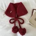 Detailed close-up of the knitted pom-pom earmuffs, featuring soft texture and lovely bow ties. - Red