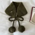 Detailed view of the cute olive green knitted earmuff with pompom and tie decoration. - Green