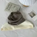 Vista de detalle del cuello alto de punto con textura acanalada suave y diseño elegante. - Café Gris