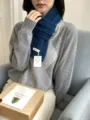 Detailed view of the dark blue cable knit wool scarf worn elegantly by a model. - One Size / Navy Blue