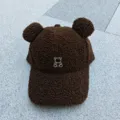 Gros plan détaillé de la casquette marron en laine d'agneau avec oreilles d'ours. - Réglable / Café