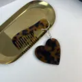 Detailed view of the stylish tortoise shell acetate heart comb keychain bag accessory. - Tortoise