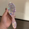 Close-up detail showcasing the premium pink pearlescent texture and comfortable ergonomic handle. - Large Massage Comb / Length 19.4x Width 6.4cm / Pink