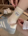 Gedetailleerd overzicht van herfst katoenen sokken met schattige beren patch en ribbels. - Beige