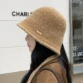 Close-up view of the cozy knit bucket hat detail featuring side metal tag and chin strap. - M (56-58cm) / Dark Khaki