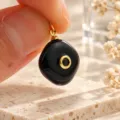 Close-up detail van zwarte onregelmatige natuurstenen hanger met gouden hardware accenten. - 1 Stuk / Zwart (13)