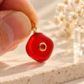 Close-up van rode snoephanger met gouden oogje en centrale steen voor DIY sieraden maken. - 1 Stuk / Rood (17)