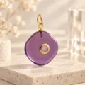 Gedetailleerd shot van een paarse geometrische edelsteenhanger met gouden oog en kristal. - 1 Stuk / Paars(20)