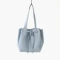 Vue détaillée du sac cabas fourre-tout en cuir véritable bleu clair avec lien noué. - Bleu