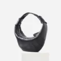 Black leather croissant underarm bag detail showing soft sheepskin texture and pleated design. - S / Black