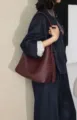 Vue détaillée du sac à bandoulière en cuir tissé de luxe porté par le mannequin avec style. - Rouge Ancorra
