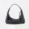 Vue détaillée du sac porté épaule souple en cuir noir, montrant une texture et une forme élégantes. - Noir