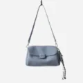 Blue-grey soft leather underarm shoulder bag detail showing fine texture and cute tassel charm. - Blue