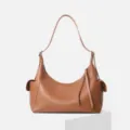 Detailed view of brown leather hobo shoulder bag featuring side pockets and zipper closure. - Brown