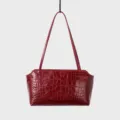 Red crocodile pattern leather detail of shoulder bag, luxury underarm handbag texture. - Red