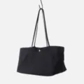 Close-up detail showing durable black canvas texture and leather shoulder strap connection. - Black