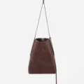 Close-up of the premium dark brown suede bucket bag showing texture and slim shoulder strap. - Coffee
