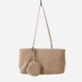 Close-up detail of the stylish suede hobo shoulder bag hanging, featuring a mini attached pouch. - Apricot