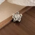 Vue de détail d'une mini pince à cheveux en métal argenté avec un design floral délicat. - Argent