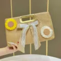 Borsa a mano in paglia intrecciata con fiocco floreale e manico dorato, elegante pochette estiva. - Beige