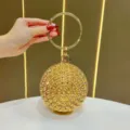 Borsa da sera rotonda in strass dorati con manico ad anello in metallo per donne. - Oro