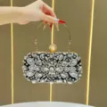 Squisita pochette da sera con strass, manico in metallo e chiusura con perla. - Nero