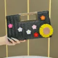 Borsa pochette in paglia nera con fiori all'uncinetto colorati e manico in metallo dorato. - Nero