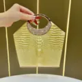 Borsa da sera dorata con motivo coccodrillo e manico rotondo in strass scintillanti. - Oro