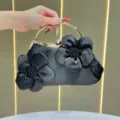 Borsa da sera nera in satin con applicazioni floreali e manico ad anello in metallo. - Nero