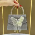 Borsa da sera scintillante in strass con un elegante design a farfalla e perle. - Nero