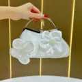 Borsa da sera bianca in raso con fiori perle e manico ad anello metallico elegante. - Bianco