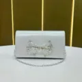 Borsa da sera pochette argentata con fiocco in strass, elegante borsa a tracolla con catena. - Argento