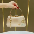 Borsa da sera in pochette di raso champagne con fiore di perla e nappa variante - Oro