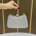 Elegant pearl evening bag featuring metal handle and stunning rhinestone clasp for party wear. - White