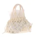 Detailopname van de vintage handgebreide nettatas met delicate stoffen rozenversieringen. - Broken Wit