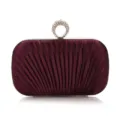 Detailed view of the purple pleated evening clutch bag with a sparkling rhinestone ring clasp. - Purple
