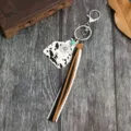 Gedetailleerd overzicht van western cowboy stijl sleutelhanger met koeienprint hanger en kwastje. - Letter D
