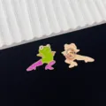 Close-up detail of the funny green frog enamel pin wearing stylish purple high heels. - Quirky Frog In High Heels Style (R321) / Green